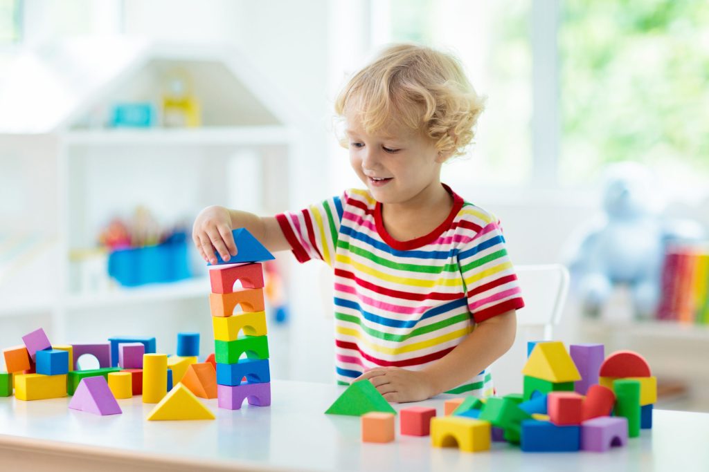 happy child playing with building blocks